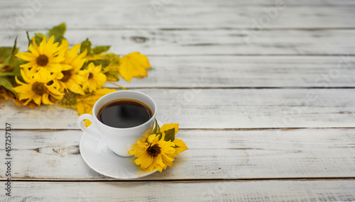 filiżanka kawy w jesienny poranek, kawa o poranku i żółte kwiaty słonecznika