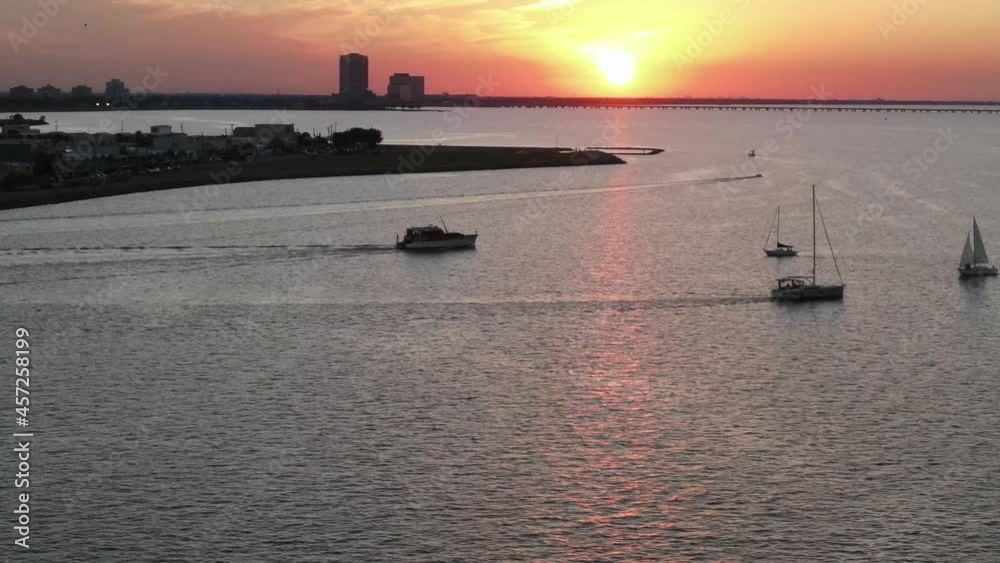 Boats Cruising At Lake Pontchartrain With Fiery Sunset In The Horizon. - aerial Boats Cruising At Lake Pontchartrain With Fiery Sunset In The Horizon. - aerial