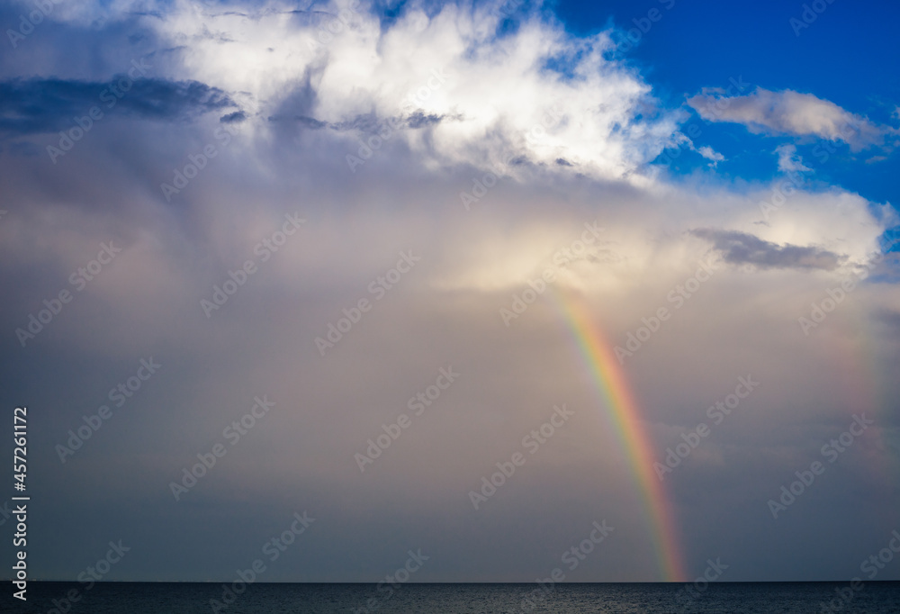Rainbow over the sea against the background of storm clouds