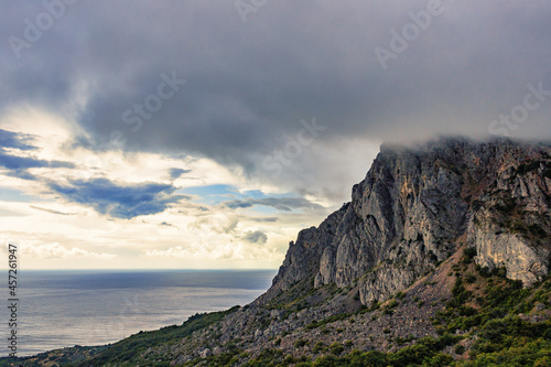 Stormy gray clouds over the mountains and the sea on the coast 