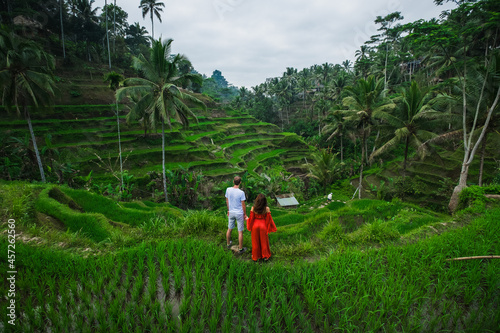 Сouple in love walking in a rice field, Bali, Indonesia.