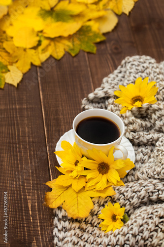 filiżanka kawy o poranku, kawa o poranku oraz słonecznikowe kwiaty i jesienne żółte liście