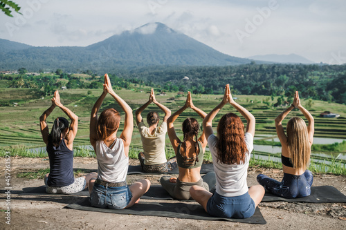 A group of yogis doing yoga, meditating in nature, in the mountains, beautiful view. photo