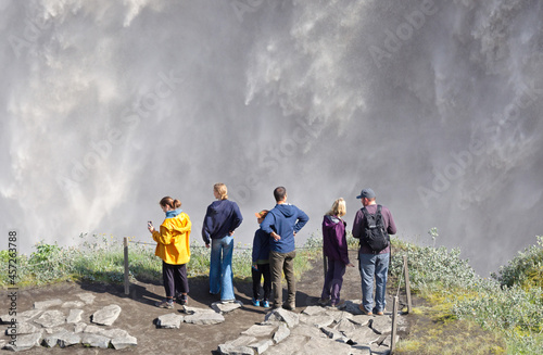 Iceland - August 3, 2021: Tourists at Dettifoss. The waterfall is situated in Vatnajökull National Park in Northeast Iceland, and is reputed to be the most powerful waterfall in Europe photo