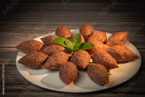 Traditional kebbe and pita bread on big round plate in lebanese restaurant. High quality photo photo