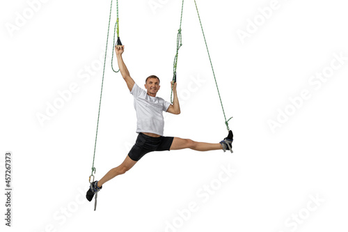 Man does splits crossfit stretching with fitness straps alpha gravity isolated on white background.