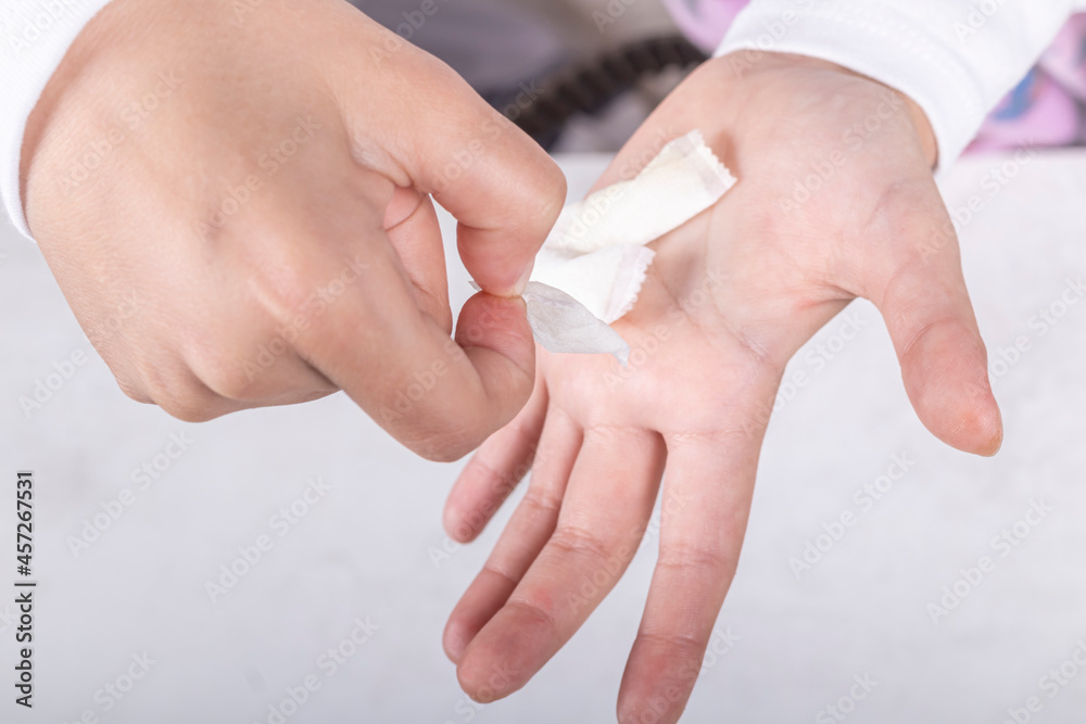 snus. the teenager's hand is in it, tobacco in bags. the background is wooden in a retro style. there is a tinting. close-up. snus. the teenager's hand is in it, tobacco in bags. the background is wooden in a retro style. there is a tinting. close-up.