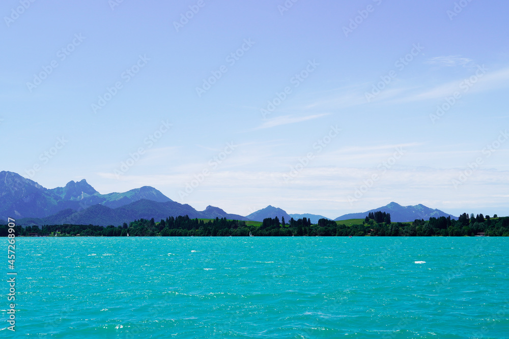 Forggensee near Füssen. Blue lake with surrounding landscape in the Bavarian Allgäu. Forggensee near Füssen. Blue lake with surrounding landscape in the Bavarian Allgäu.