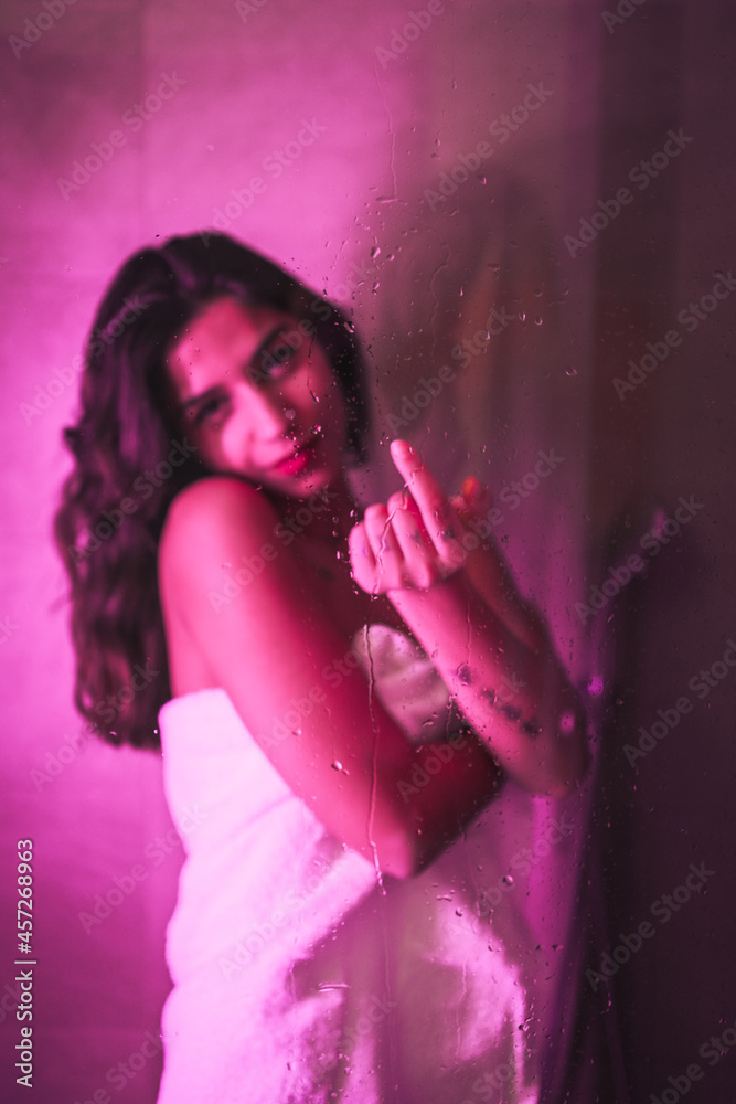 Lifestyle, sexy brunette Caucasian girl with towel at the end of the shower with sensual look, with pink led light, portraits inside the wet shower Lifestyle, sexy brunette Caucasian girl with towel at the end of the shower with sensual look, with pink led light, portraits inside the wet shower