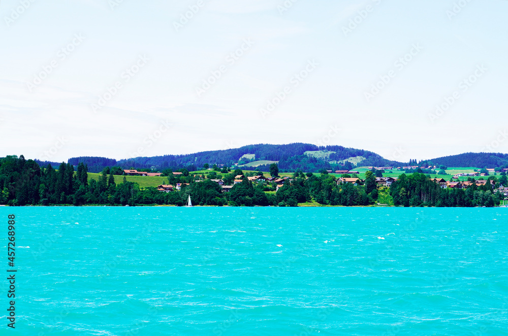 Forggensee near Füssen. Blue lake with surrounding landscape in the Bavarian Allgäu.