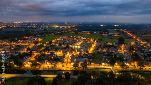 Aerial of a residential area seen from above during a dark grey cloudy sunset in Sint Jozef, Rijkevorsel, Antwerp, Belgium, shot by a drone. High quality photo