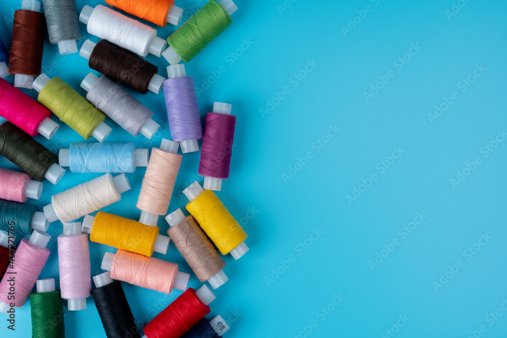 Multicolor sewing threads on a blue background Multicolor sewing threads on a blue background