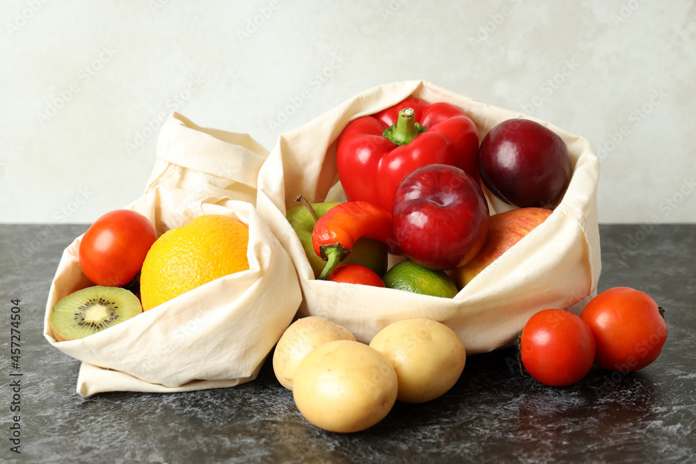 Bags with vegetables and fruits on black smokey table Bags with vegetables and fruits on black smokey table