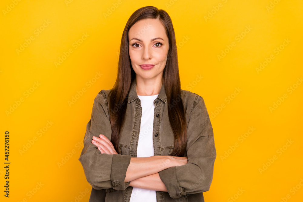 Photo of charming confident happy mature woman hold hands crossed isolated on yellow color background Photo of charming confident happy mature woman hold hands crossed isolated on yellow color background