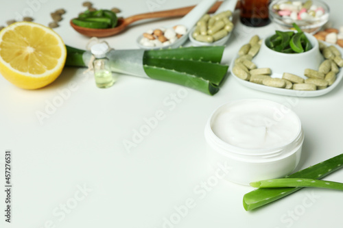 Concept of herb pills and cosmetics with aloe on white background