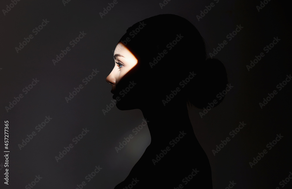 beautiful girl in the dark. young woman with shadow