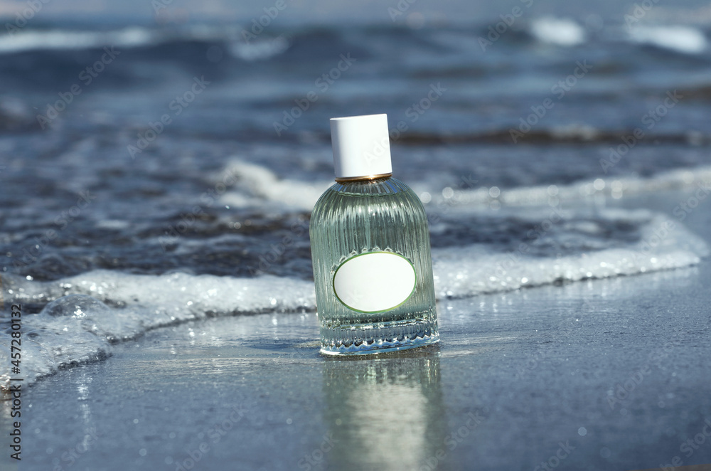Premium Photo  Blue perfume bottle mock up stands on wet sand on the  background of waves and the sea on the beach