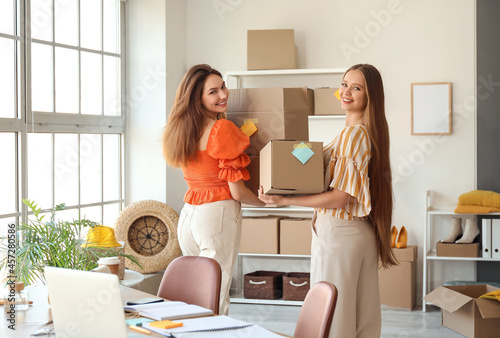 Small business startup and e-commerce logistics, two women packing cardboard ...