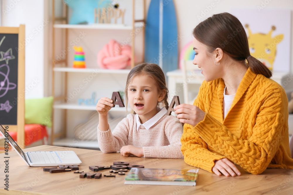 Speech therapist working with cute girl in clinic Speech therapist working with cute girl in clinic
