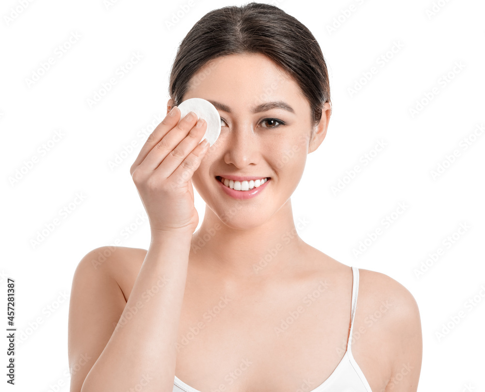 Beautiful young Asian woman with cotton pad on white background Beautiful young Asian woman with cotton pad on white background