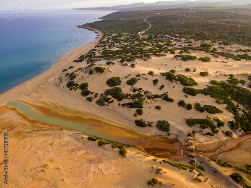 Aerial view of dunes of piscinas capo pecora porto palmas sardinia at sunrise with full view of red river manmade mines environment 