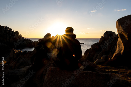 traveller silhouette at sunset with sun star and rock shapes