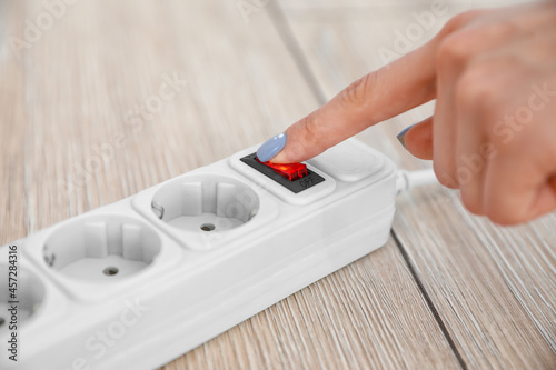 Woman with extension cord in room, closeup