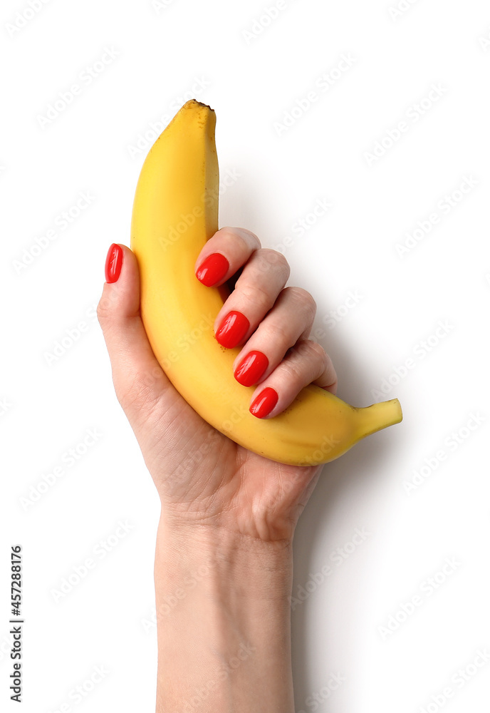 Woman with beautiful manicure holding banana on white background Woman with beautiful manicure holding banana on white background