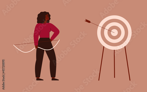 Businesswoman shooting a bow and hit a target. Archery to the bull’s-eye of the dartboard. A strong girl achieves her goals in her life and career. Concept of accuracy business strategy and victory.