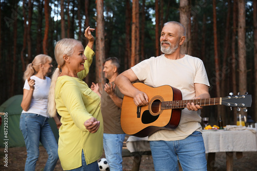 Mature man playing guitar a...