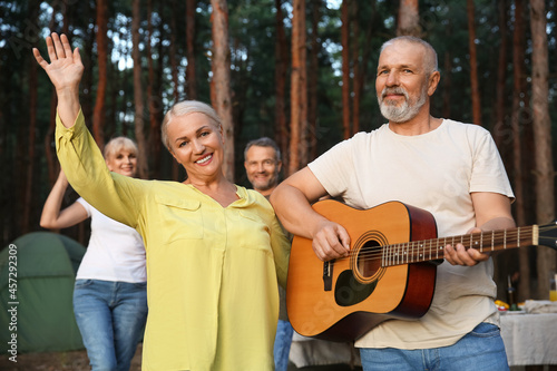 Mature man playing guitar a...