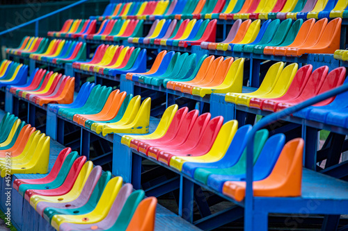 Empty rows of colorful chairs on the stadium podium. Colorful places for the public