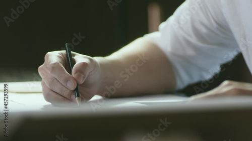 closeup shot of designer's hand sketching on paper when thinking indoors