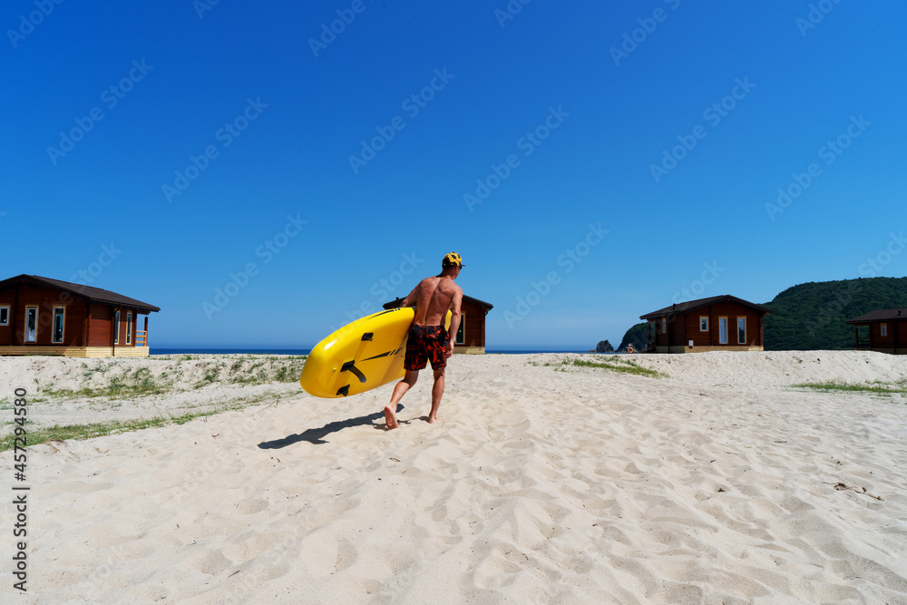 Active male surfer running with surfboard on sand beach enjoying healthy lifestyle extreme sport Active male surfer running with surfboard on sand beach enjoying healthy lifestyle extreme sport