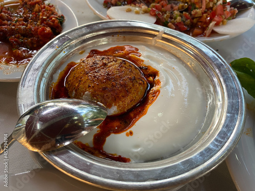 Syriac Kitel Raha icli kofte.  Boiled kibbeh  Quibe with butter yogurt sauce. photo