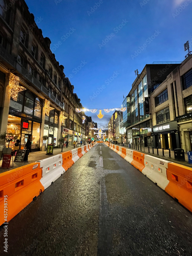 Fototapeta premium City street at night with buildings and moving traffic. Taken in Manchester England. 