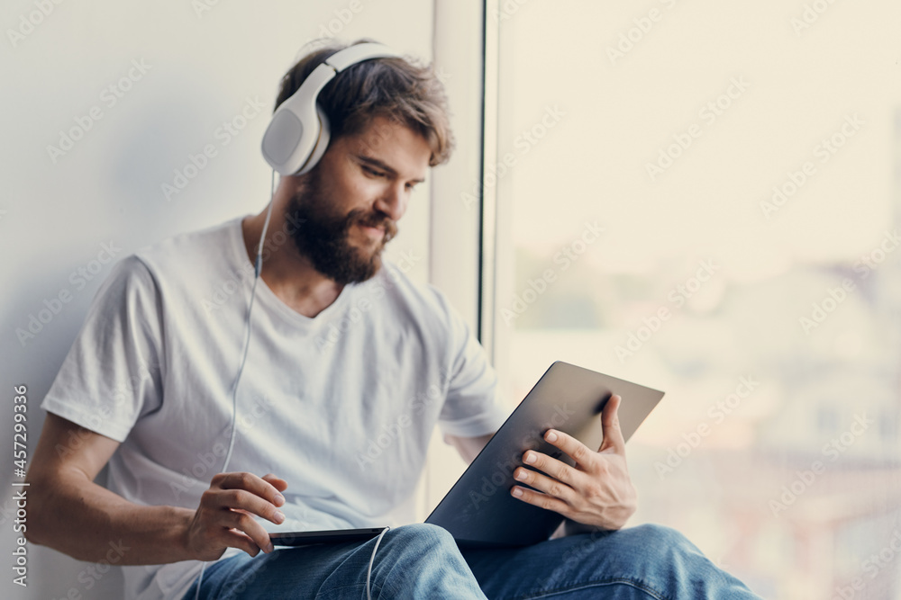 Cheerful man sitting on the windowsill relaxation Cheerful man sitting on the windowsill relaxation