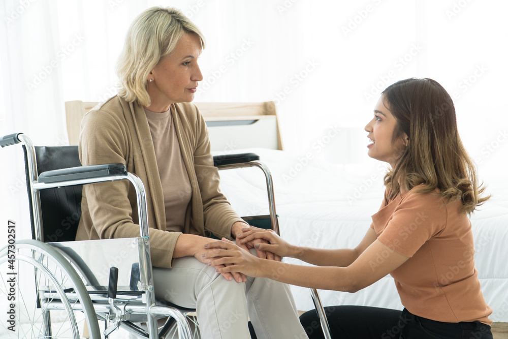 Obraz premium Grown-up daughter Take care mother sit wheelchair