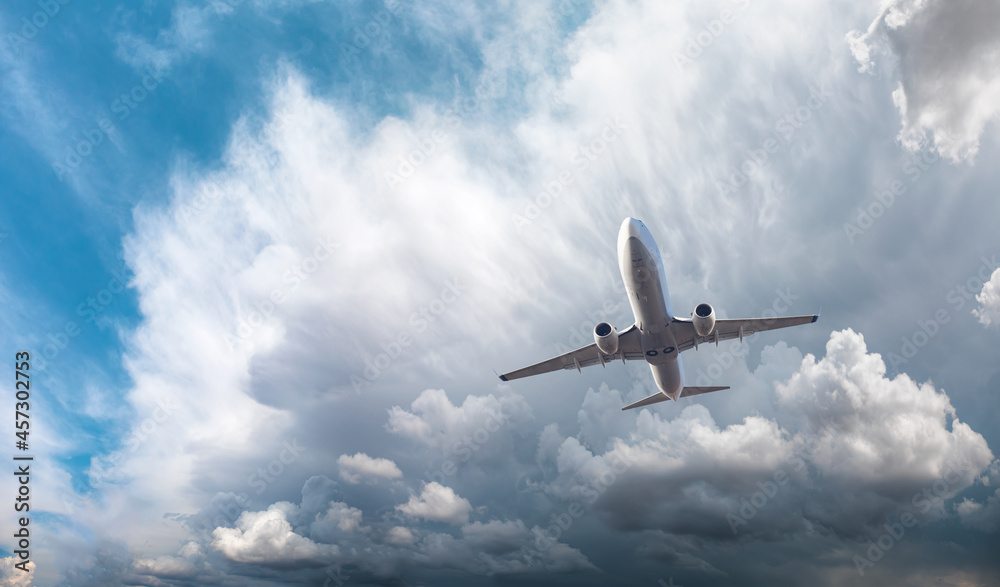 White passenger airplane over the stormy dark clouds - Travel by air transport White passenger airplane over the stormy dark clouds - Travel by air transport