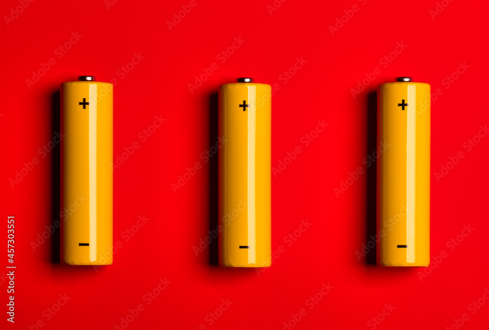 Yellow AA alkaline batteries on red background Yellow AA alkaline batteries on red background