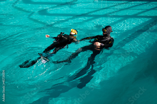 Woman and male divemaster, lesson in diving school