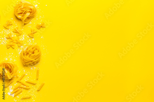 Different tipes of pasta with flour ready for cooking, flat lay photo