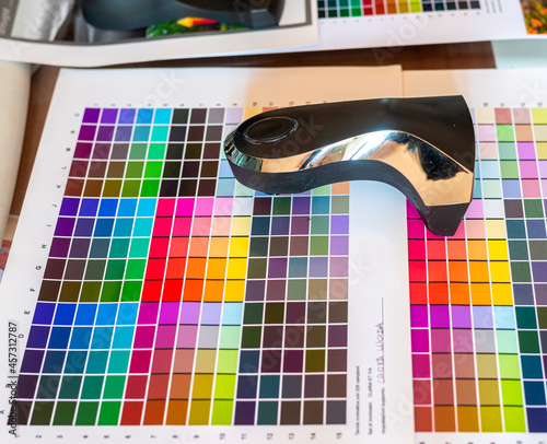 Technician uses a spectrocolorimeter to read patches with various colors for color management related to creating an icc color profile for the printer photo