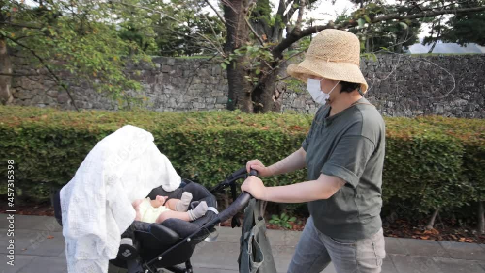 Mother walks with baby on a stroller at castle park Mother walks with baby on a stroller at castle park