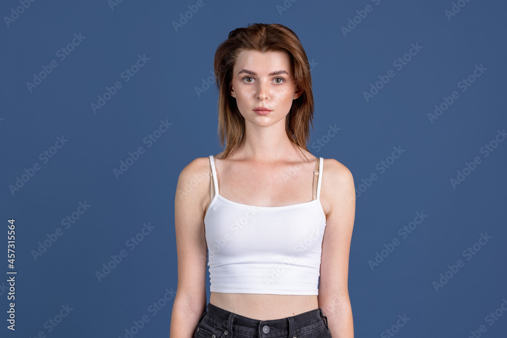Traditional portrait of young girl isolated on old navy color studio background. Concept of human emotions, facial expression, natural beauty, appearance, youth Traditional portrait of young girl isolated on old navy color studio background. Concept of human emotions, facial expression, natural beauty, appearance, youth