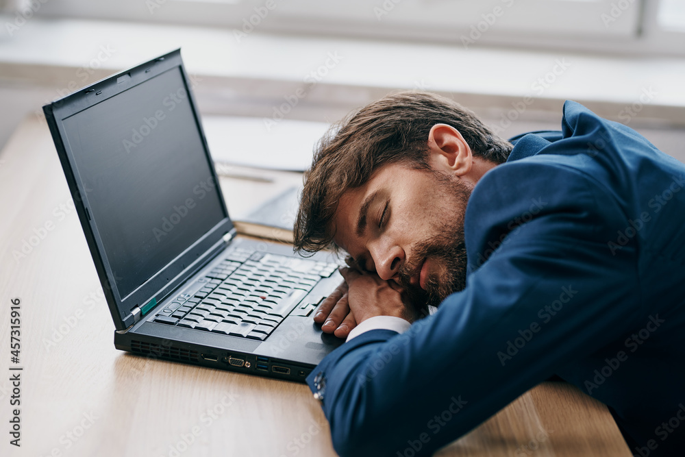 business man sleeping in front of laptop at his desk office business man sleeping in front of laptop at his desk office