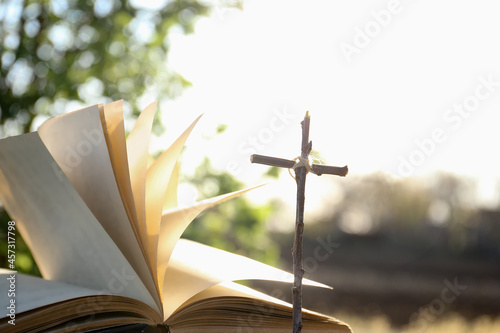 The Bible on the background of the cross and life-giving light