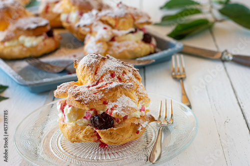 Bild auf Leinwand Cream puffs with whipped cream and cherries