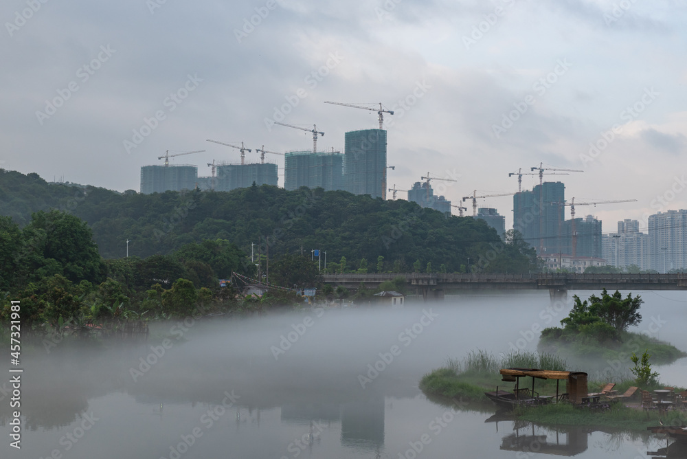 The scenery on both sides of the river in the morning fog