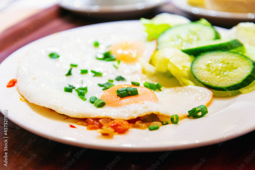 Two delicious poached eggs with salmon on toast served with mixed vegetables and lettuce in white ceramic plate Two delicious poached eggs with salmon on toast served with mixed vegetables and lettuce in white ceramic plate